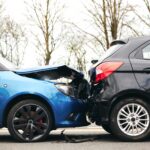 Delivery vehicle accident with a blue car and a black car, showing rear-end collision damage, relevant to insurance advice for delivery service partners.